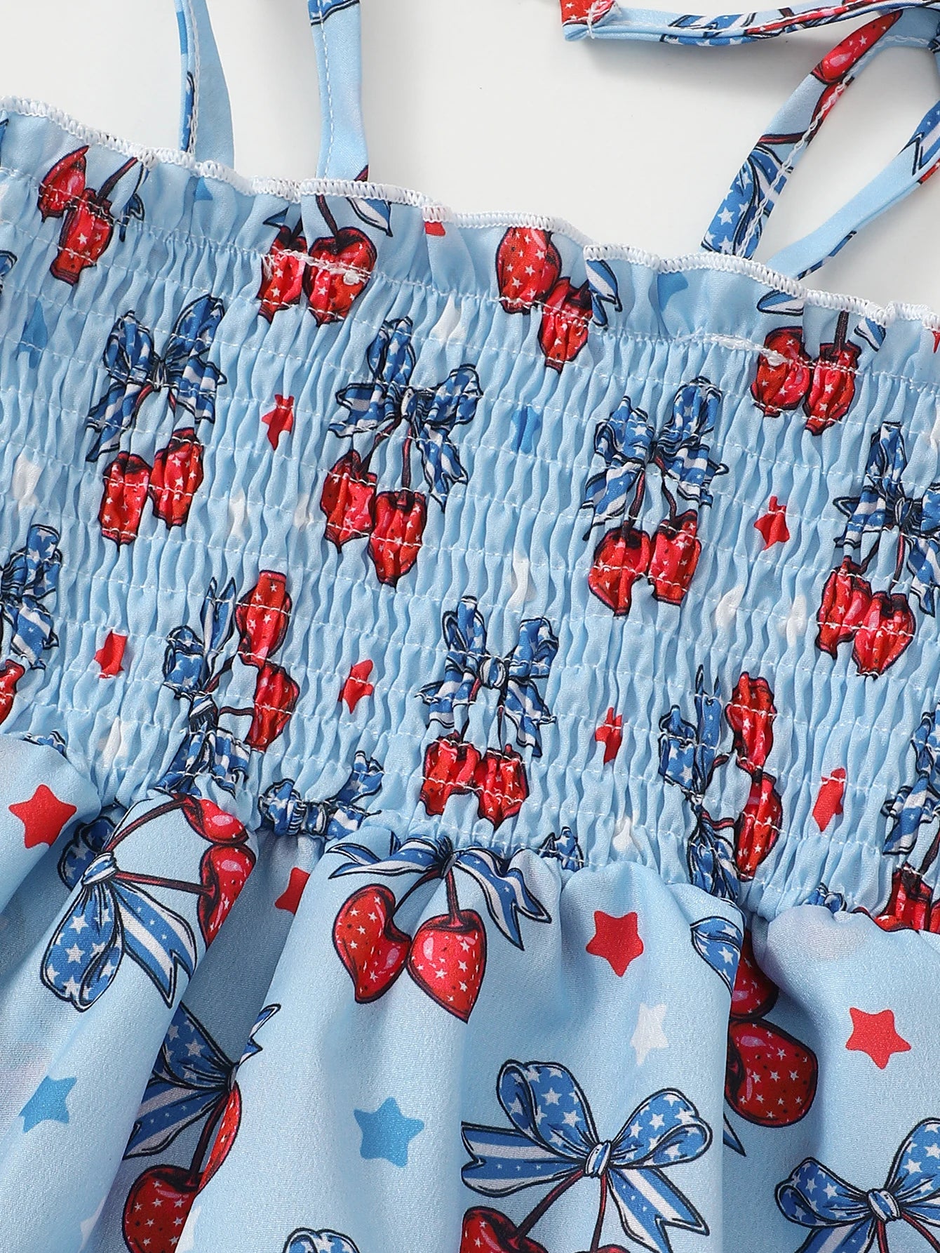 Barboteuse pour bébé fille Petit Trésor avec imprimé cerises, tissu léger pour l'été, motif coloré et confortable.